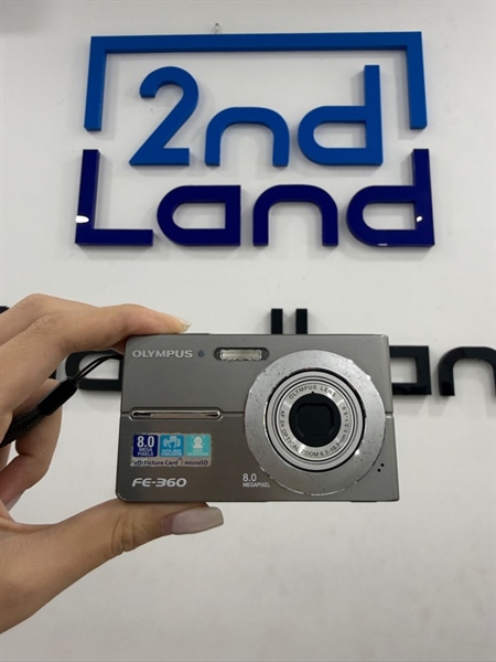Máy ảnh Digital Olympus FE-360 - Màu bạc - Ngoại hình 97% - Màn chết 1 chấm pixel , liệt mũi tên trái và xuống , kính mốc , bụi , cấn 1 góc , trầy vòng lens bị oxi hóa - Kèm 1 pin linh kiện , 1 thẻ 2GB , sạc